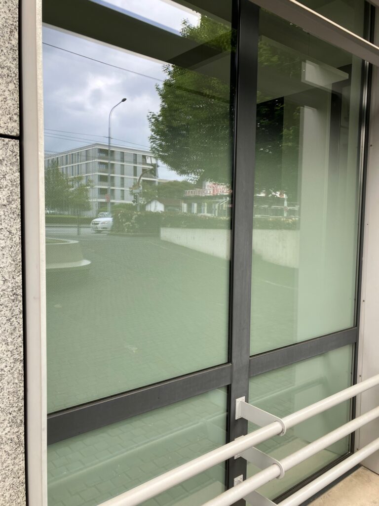 Installation de film occultant et protection solaire sur vitrage de bâtiment à Genève - Lettra Système